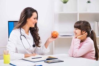 Start with Small Goals - IHBLT - Doctor holding fruit with young patient