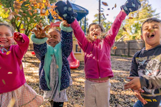 Kids Throwing Leaves on Playground